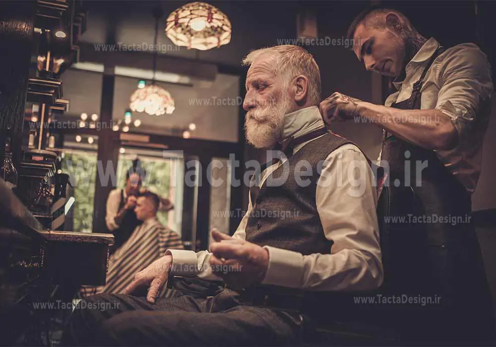 یک آرایشگر جوان در حال اصلاح مرد کهنسال